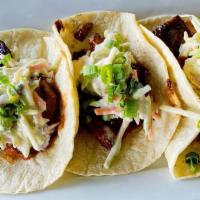 Bbq Burnt End Tacos · BBQ Burnt Ends topped with Kohlrabi slaw & Green Onions, served on corn tortillas