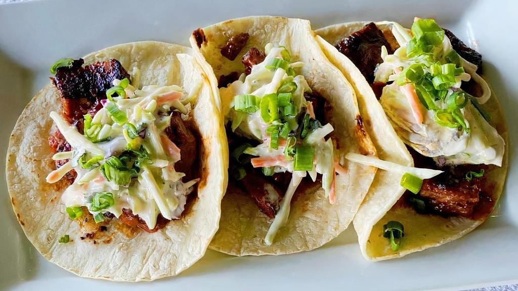 Bbq Burnt End Tacos · BBQ Burnt Ends topped with Kohlrabi slaw & Green Onions, served on corn tortillas