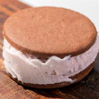 Chocolate Alfa-Lato · Chocolate alfajor cookie sandwich filled with strawberry gelato dipped in chocolate.