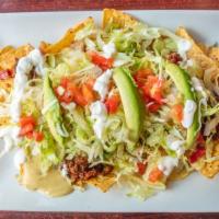 Nachos Supreme · Tortilla chips, topped with beans, ground beef, cheese dip, tomatoes, lettuce, sour cream an...