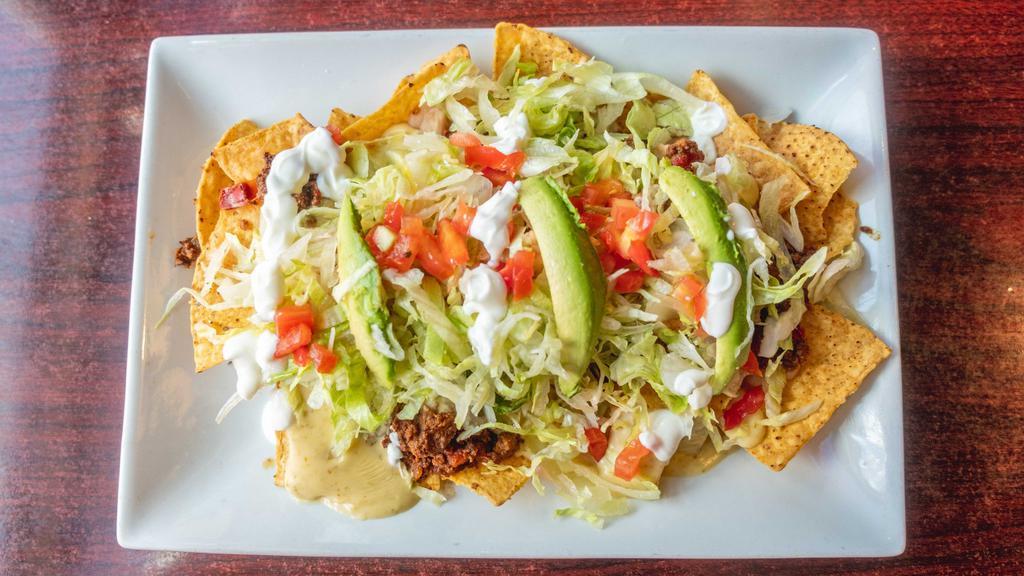 Nachos Supreme · Tortilla chips, topped with beans, ground beef, cheese dip, tomatoes, lettuce, sour cream and avocado. Add meat for an additional charge.