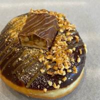 Snickers · Filled with house made caramel pastry cream, dipped in chocolate ganache, sprinkled with cru...