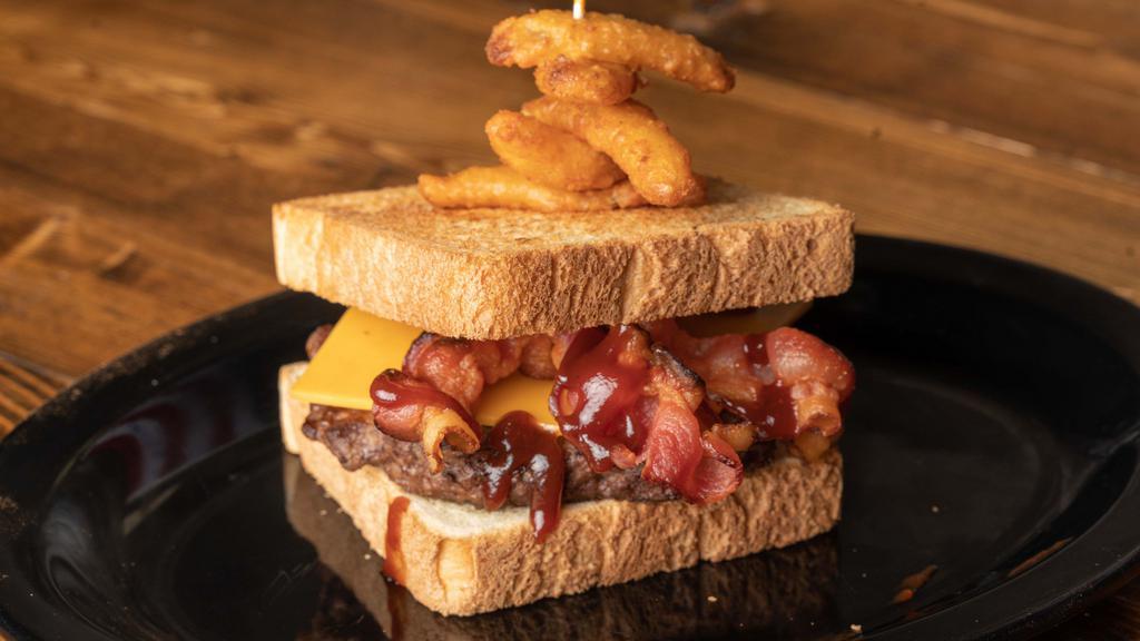 The Texan · Cheddar cheese, bacon, BBQ, onion petals served on texas toast.