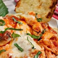 Baked Chicken Parmesan Pasta · Penne pasta tossed with parmesan cream sauce, topped with fried chicken breast, marinara sau...