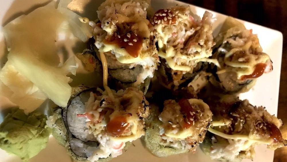 Volcano Roll · Inside cooked shrimp, crab stick and cream cheese, avocado, topped with crab salad then torched and drizzled with teriyaki, mayo & siracha, torched.