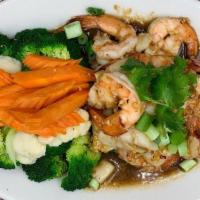 Shrimp & Scallops · Scallops & shrimp stir-fried in a fresh garlic and white wine sauce, served with steamed car...