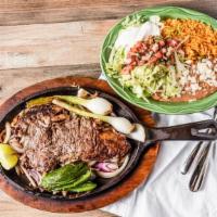 Carne Asada A La Mexicana · Tender Steak grilled with onions. Served with rice, beans, guacamole salad and choice of cor...