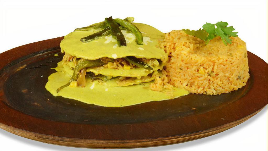Pastel Azteca (Mexican Lasagna) · Layers of deep fried corn tortilla covered with shredded chicken roasted poblano peppers, onions, and roasted corn. Covered with cheese and topped with our special creamy poblano sauce. Served with rice.