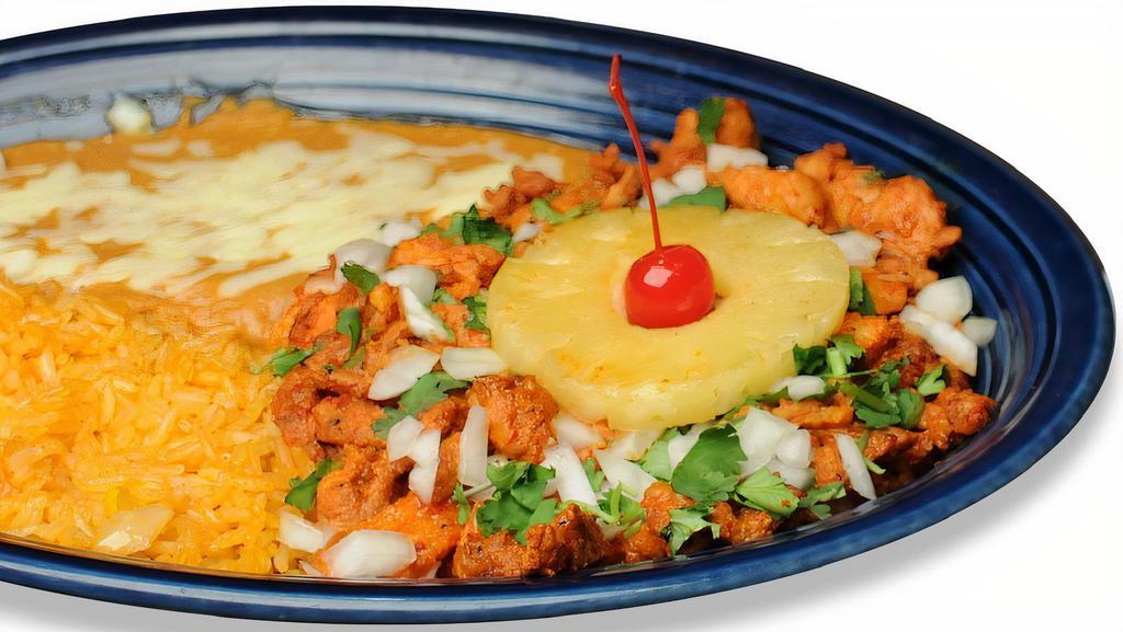 Al Pastor Especial · Pork tenderloin marinated in special pineapple sauce cooked with onions. Covered with melted cheese. Garnished with pineapple slices, a cherry, and cilantro. Served with rice, beans and your choice of corn or flour tortillas on the side.