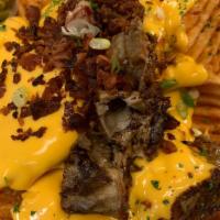 Animal Fries · Waffle fries, nacho queso, scallions, sour cream topped with bacon bits and smoked brisket.