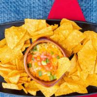 Buffalo Dip · Creamy house-made dip topped. with tomato & scallions. Served. with tortilla chips & celery