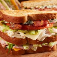 Bennigan’S Club™ · Honey wheat bread, toasted and seasoned with freshly made basil mayonnaise. Layered with ten...