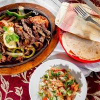 Fajitas Al Carbon · Sliced skirt steak grilled with onions, tomatoes, green peppers and poblano peppers.