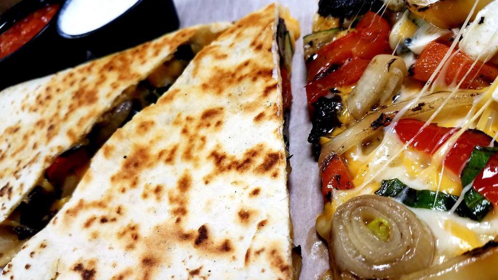 Grilled Veggie Quesadilla · This is a folded quesadilla loaded with grilled zucchini, portobello mushrooms, red bell pepper & onions with our signature cheese blend, fresh mozzarella cheese and fresh basil.