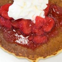 Strawberry Pancakes · Stack of three golden brown pancakes topped with strawberries.