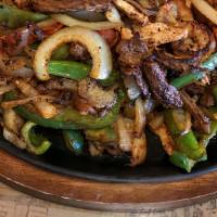 Texas Fajitas · Tender beef, chicken and shrimp marinated then grilled with vegetables. Served with guacamol...