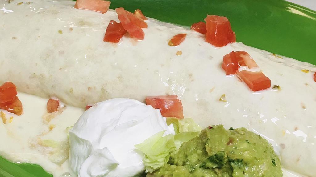 Burrito Telcome · Large flour tortilla stuffed with your choice of chicken, ground beef or shredded beef, rice and beans inside. Smothered with cheese dip sauce and topped with chopped tomatoes. Add steak or grilled chicken for an additional charge.