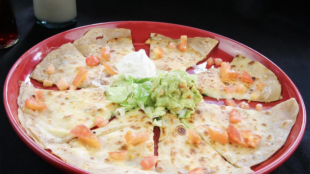 Quesadilla · Soft flour tortillas stuffed with melted cheese, onions and tomatoes. Served with sour cream and guacamole. Add chicken, ground beef or shredded beef. Carne asada for  an additional charge.