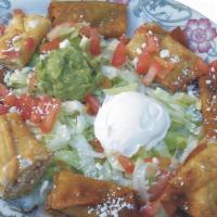 Chicken Taquitos · Crisp flour tortilla with fresh chicken on a bed of lettuce, garnished with tomatoes cheese ...