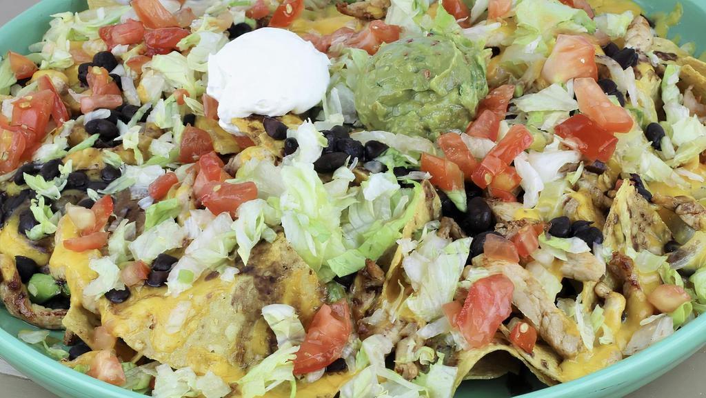 Fajita Nachos · A platter of fresh house made tortilla chips topped with your choice of marinated chicken or beef, grilled onions and bell peppers. Topped with black beans and garnished with lettuce, tomato, guacamole and sour cream.