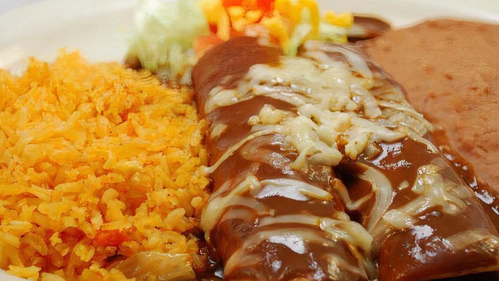 Mole Enchiladas · Two corn tortillas stuffed with tender shredded chicken. Topped with delicious sweet spicy mole sauce.