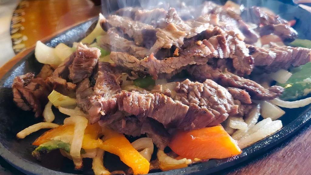 Steak Fajita · A sizzling grilled dish with sauteed onions and green peppers. served with rice beans guacamole sour cream pico de gallo and cheese.