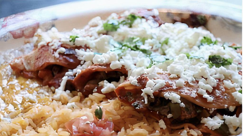 Tacos Al Carbon · Flame broiled skirt steak slices and folded into a soft corn tortilla with Mexican salsa, topped with ranchero cheese. Served with rice and beans.