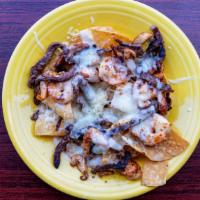Texas Nachos · With tender steak, grilled chicken and shrimp. Served over tortilla chips covered with our f...