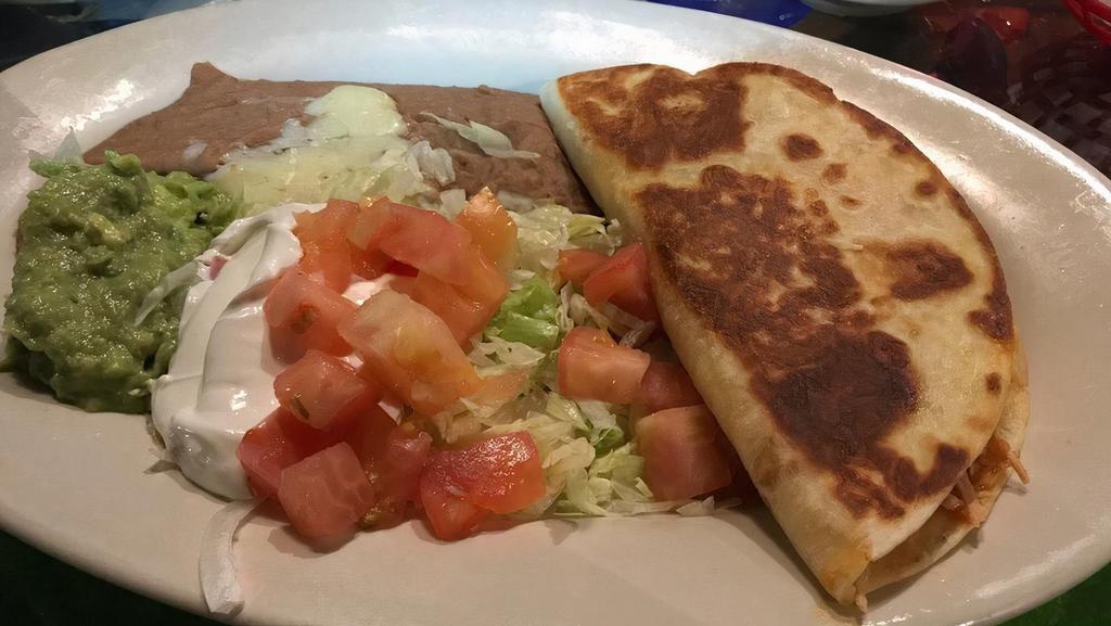 Quesadilla Rellena · Our cheese quesadilla stuffed with your choice of ground beef, shredded beef or shredded chicken. Served with fresh lettuce, tomatoes, cool sour cream and guacamole. With choice of rice or beans.