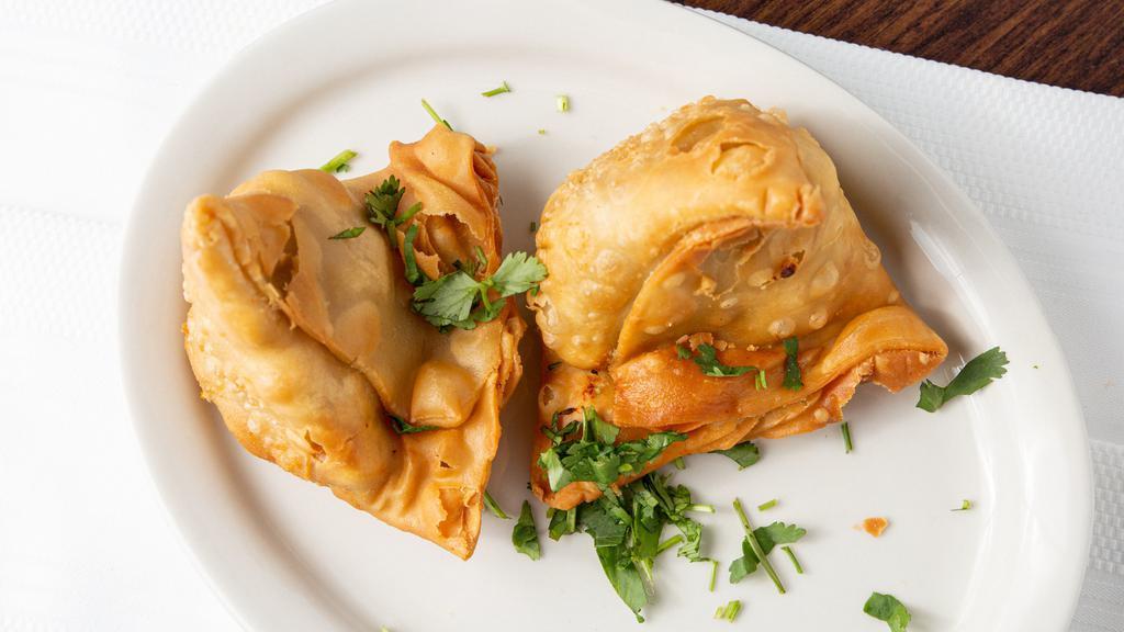Samosa · Deep fried crispy pastry turnover filled with mashed potato & peas served with tamarind chutney.