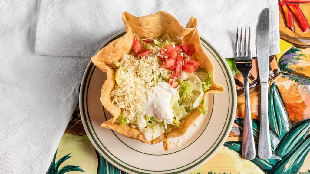 Taco Salad · Flour tortilla bowl filled with beef or chicken, cheese, beans, lettuce, tomato and sour cream.