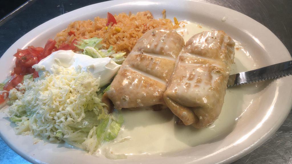 Chimichanga Dinner · 2 flour tortillas fried, filled with shredded chicken or ground beef and convered with cheese sauce. Served with rice or beans and lettuce, tomatoes and sour cream.