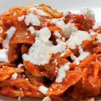 Chilaquiles · Tortilla chips simmered in spicy tomatillo or mild sauce with cheese, sour cream and onion.