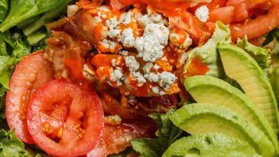 Buffalo Chicken Salad · Mixed greens, sliced chicken breast tossed with spicy wing sauce, bacon, crumbled Bleu cheese, avocado, plum tomatoes, croutons, side of ranch dressing. 504 cal.