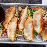 Potstickers · Pork dumplings on a bed of slaw served with a asian infused sauce topped with scallions