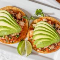 Tostadas De Ceviche · Two tostadas layered with avocado and fresh shrimp, marinated in lime juice, cilantro, onion...