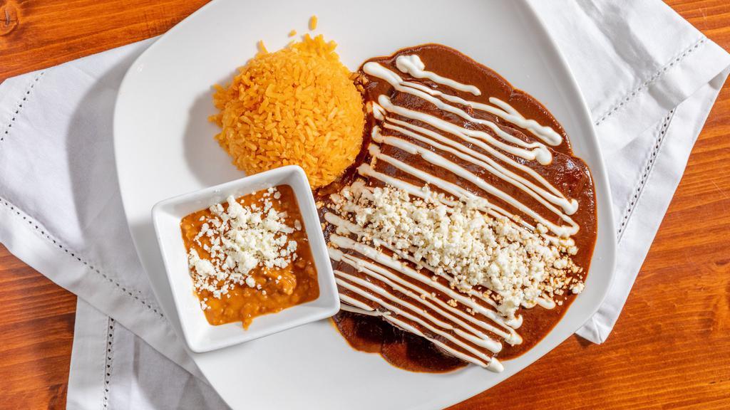 Enchiladas De Mole Dinner · Three rolled up corn tortillas stuffed with your choice of meat, topped with our delicious mole poblano sauce, queso fresco (mexican cheese), and sour cream. Served with spanish rice and beans.