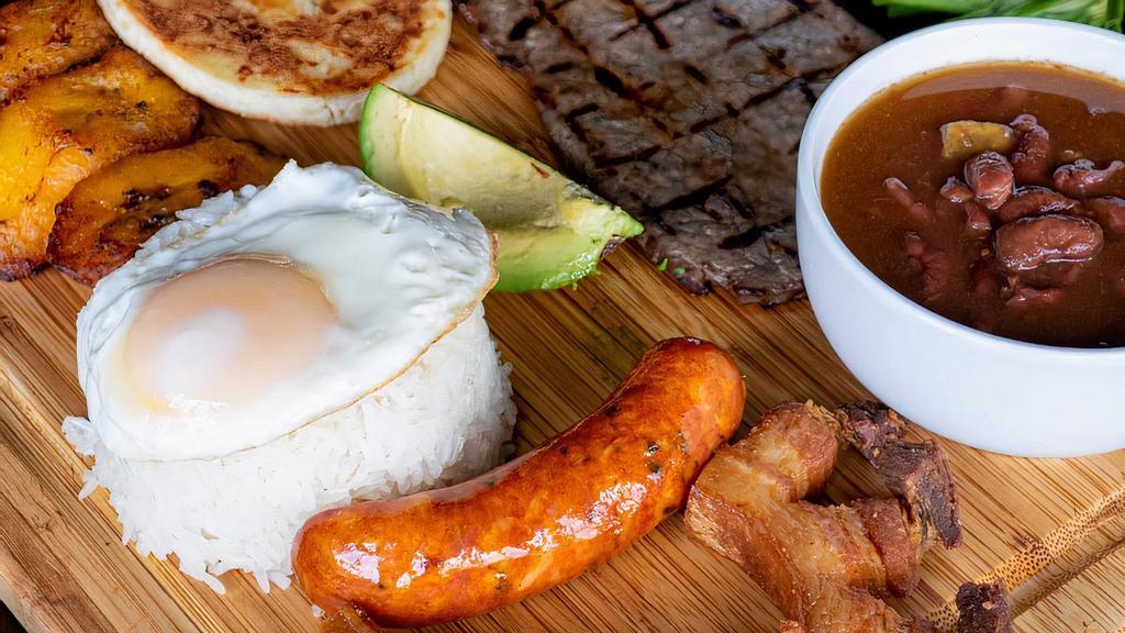 Bandeja Paisa · Grilled sirloin served with rice, egg, beans, pork rind, avocado, white cornbread, Colombian sausage, and sweet plantains.