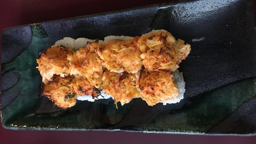 Volcano Roll · Cooked sushi in red. Explosively delicious! A spicy, creamy blend of scallops, crab, scallion and masago baked on top of a California roll.