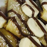 Nutella Crepes · Nutella and freshly sliced bananas topped on warm sweet crepes. Sprinkled with powdered suga...