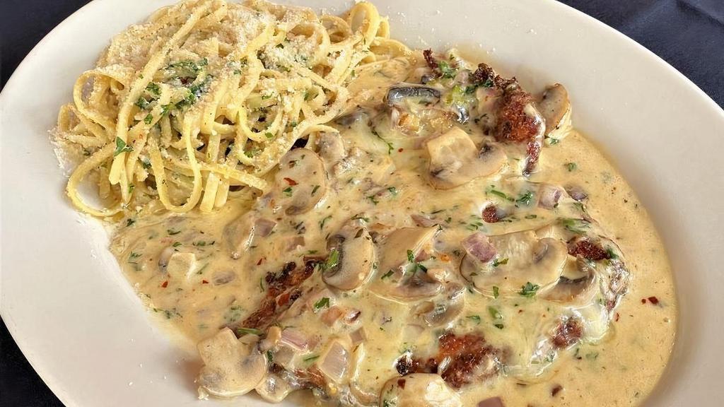 Chicken Vincenzo · Lightly breaded, crispy and topped with fontina cheese with sauteed mushrooms, garlic and onions and finished in a spicy cognac cream reduction.  Served with linguine in olive oil and garlic