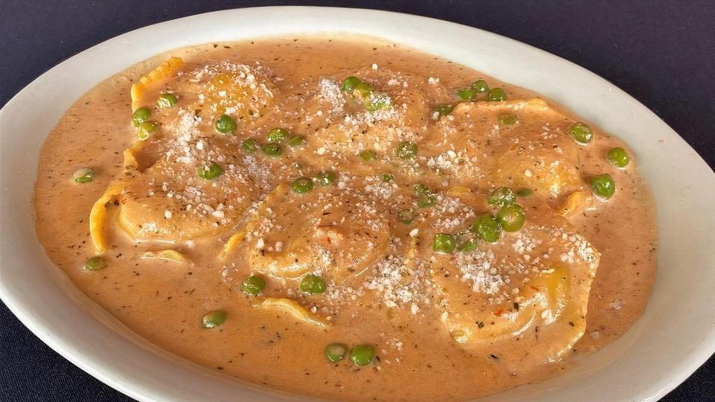 Seafood Ravioli Mario · Filled with shrimp, scallops and lobster in a sherry wine sauce with roasted tomatoes, peas and fresh herbs with romano cheesse