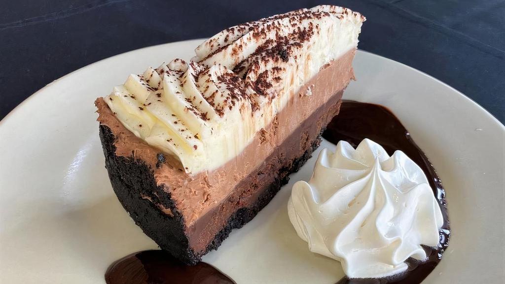 Chocolate Mousse Cake · Chocolate cookie crumb crust layered with fudge, chocolate and white chocolate mousses