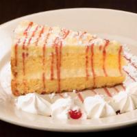 Limoncello Cake · Layered with mascarpone and topped with white chocolate shavings and raspberry sauce