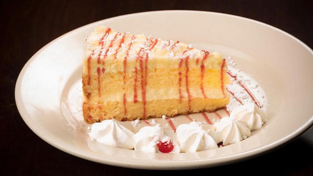 Limoncello Cake · Layered with mascarpone and topped with white chocolate shavings and raspberry sauce