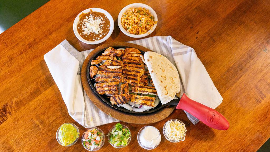 Fajitas · Filling of your choice, sauteed with onions and bell peppers. Served with lettuce, sour cream, cheese, guacamole and flour tortillas. Rice and beans on the side.