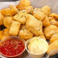 Beer Nuggets · Lightly fried pizza dough tossed with garlic butter and parmesan, served with marinara.