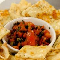 Pizza Chips With Fresh Tomato Salsa · Baked seasoned dough chips served with fresh tomato salsa.