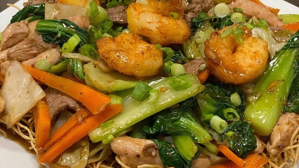 Combo Mi Xao · Beef, Chicken & Shrimp stir fry with cabbage, bok choy, carrots & onions in a savory dark sauce, served over a bed of crispy fried egg noodles.