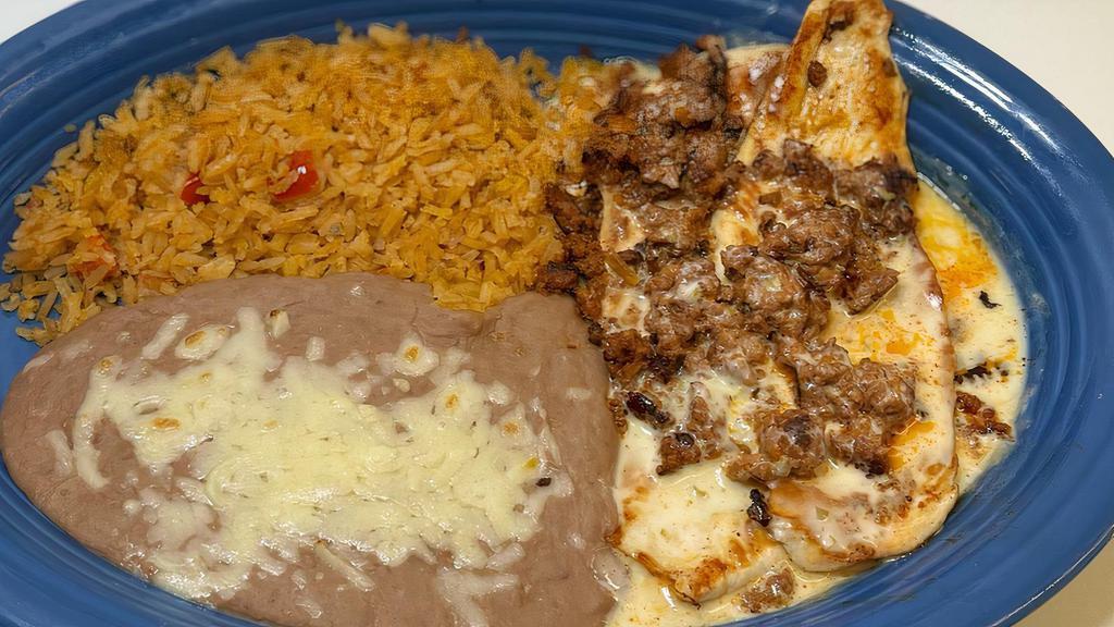 Pollo Con Chorizo · Grilled chicken breast topped with chorizo and white cheese sauce, served with rice, beans and flour tortillas.